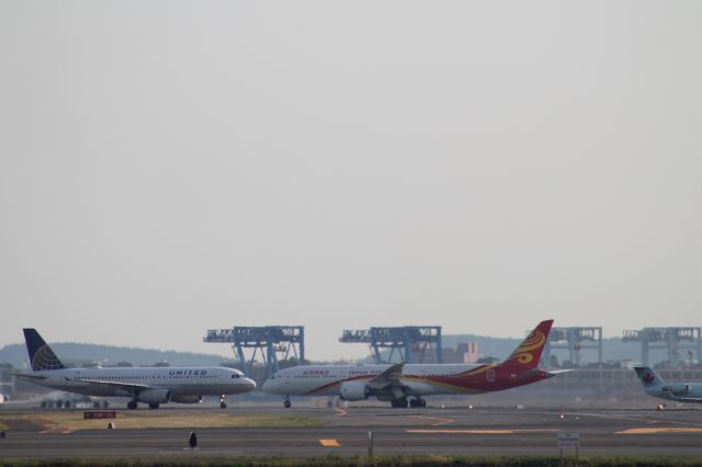 Boeing 787-9 Dreamliner (B-7837) - Hainan 787-9 taking off from 33R. Nice shot with the United A320 as they appear to be coming head on at each other, but they arent.