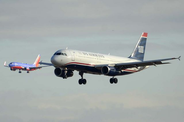 Airbus A320 (N677AW) - US Airways Airbus A320-232 N677AW and Southwest 737 on approach to land on the parallel runways  at Phoenix Sky Harbor on December 20, 2015. A320-232 N677AW first flew as F-WWBJ on April 13, 2005. Its construction number is 2430. It was delivered to America West on May 6, 2004. It was transferred to US Airways on June 15, 2007. 