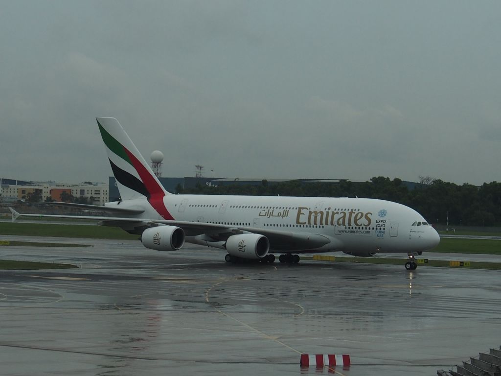 Airbus A380-800 — - A380 taxying to stand Changi dull & wet. From departures.