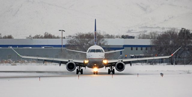 Embraer 175 (N167SY) - A combination snow and ice storm had just ended and this Skywest Embraer arrival from SFO became the first aircraft to land on the plowed, but very slippery, runway 16R. In so doing, it provided me with this extremely rare photo angle. Most aircraft, after landing on the 11,002 foot long 16R, exit at some location midway down the runway. However, on this bleak early morning just moments after the storm had stopped, and because every taxiway was closed except at each end of runway 16R-34L, this flight had no choice after landing but to taxi all the way to the end of 16R in order to exit the runway and gain access to taxiway Alpha, which was the only open taxiway. And that meant it would be turning directly toward me as it came off 16R. The odds are very much against this opportunity ever occurring for me again. So despite the gray early morning light conditions, this one is a rather special capture for me.