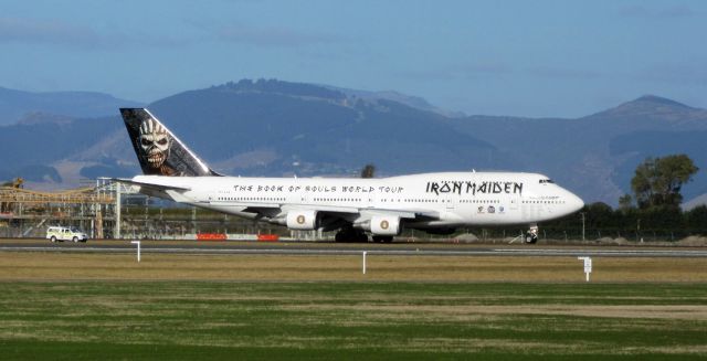 Boeing 747-200 (TF-AAK) - Ed Force 1 taxiing to hold at Runway 02, en-route to Auckland (AKL) for Iron Maidens next concert. Note the utility vehicle, which as well as firing a few rounds from a shotgun, also has a loud-speaker playing falcon screeches to scare birds away. Keep in mind this is New Zealand; sheep graze next to the tarmac and security dont care if you park in the flight path to watch.br /30 April 2016