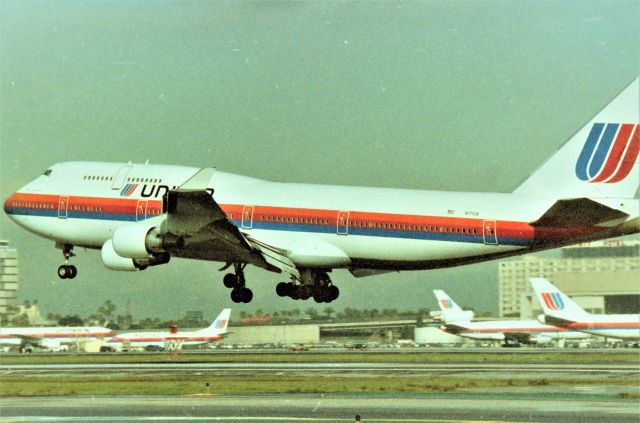 Boeing 747-400 (N171UA) - KLAX - Sept 1989 down in LAX for the Airline Collectible show that year at the Hacienda Hotel on Sepulveda, my 60-300mm failed me or I'm a crummy photog - parked at the FedEx lot off Douglas Ave at Los Angeles, I saw this 747-400 on final for 25L..and could see it was United! I had not seen any new 747-400s for United and here was my 1st time, I had the video and my 35mm slung around my neck...." video or print, print of video" I kept asking myself as this gleaming new 747 was approaching fast - I decided prints and I'd get the next one on video. Bad part was another UAL new 747-400 never showed up while I was here....! I have a series of this jet landing here but opted for the other UALs in the background for fun. Shown here is the "Spirit of Seattle" CN:24332 LN" 733 - one of the 1st 747-400s for United.