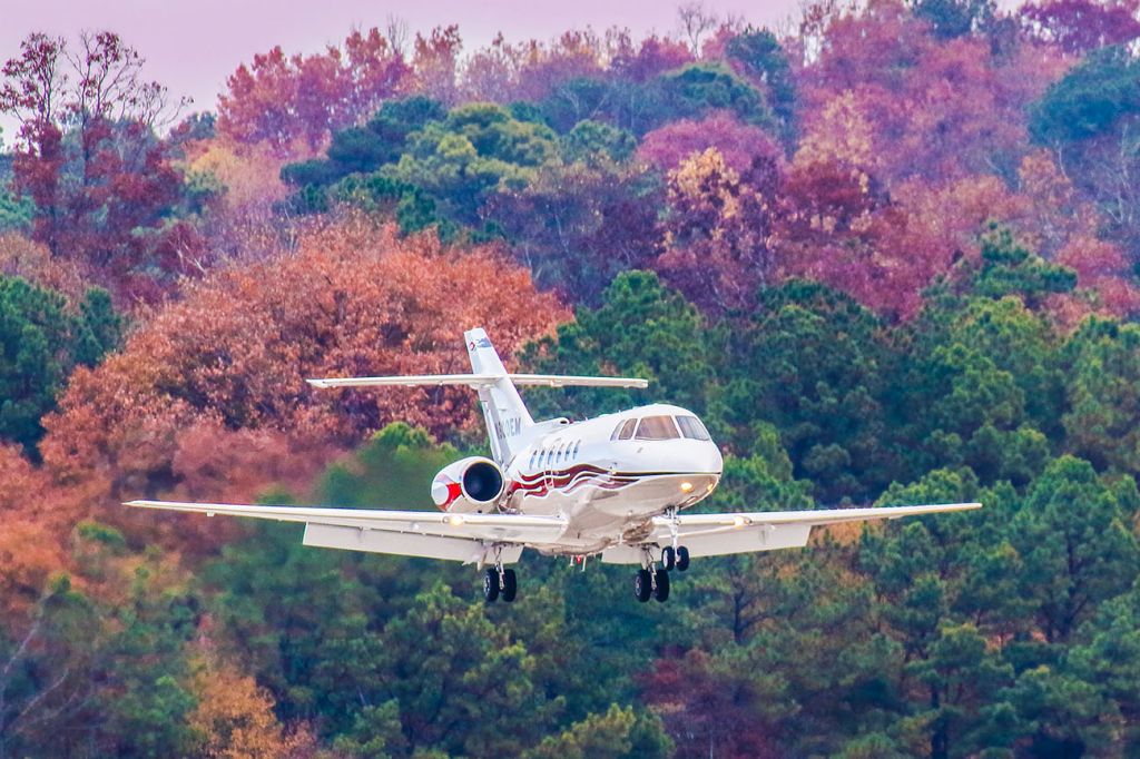 Hawker 800 (N800EM) - On an early evening at Atlanta's PDK airport there wasn't much traffic, then I saw a jet inbound. I was using my Canon 600mm lens and waited and waited until the timing was right and I got this amazing colorful image. Not only were the leaves in full color, but this jet has a crazy cool flame paint job. My camera settings were 1/1000 shutter, F4, ISO 800. Please check out my other aviation photography. Votes and positive comments are always appreciated. Questions about this photo can be sent to Info@FlewShots.com