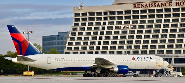 BOEING 767-300 (N1402A) - Awaiting taxi to a gate for departure to Salt Lake City. The famous Renaissance Hotel is in the background.