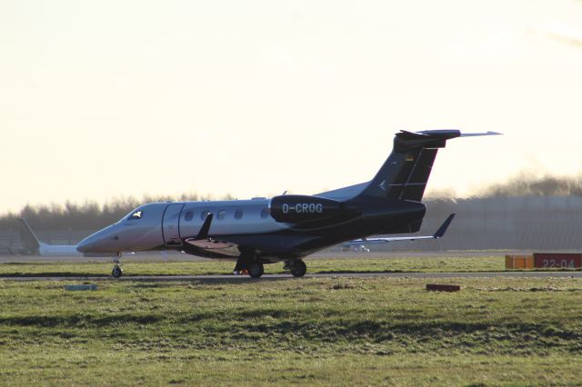 Embraer Phenom 300 (D-CROG) - An Air Hamburg Embraer Phenom 300 taxiing to runway 22 at STN.br /br /Location: Stansted Airport.br /Date: 26.12.22 (dd/mm/yy).