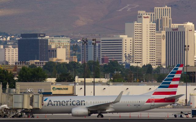 Boeing 737-800 (N971NN) - This first gallery photo of Americans new N971NN in the morning light needs no actual description.  The picture pretty much tells the story of what gate it is at and the name on the City Hall building in the background tells what city it is visiting.  And that big white "R" on the side of Peavine Mountain also gives a darn good hint of the city, too.br /Although the FA info bar under this photo indicates that there is already a previous post of N971NN in the gallery, this photo is, in fact, the first shot on this aircraft.  The other photo, posted about a year ago, is misidentified.  It is actually a pic of N971AN.  The aircraft shown above did not exist a year ago.  