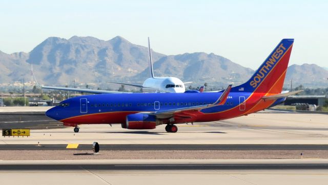 Boeing 737-700 (N782SA) - Southwest Boeing 737-7H4, N782SA, taxiing in front of a Hawaiian Airlines 767-300 at PHX.  Taken from seat 12A on an AA B737-832.