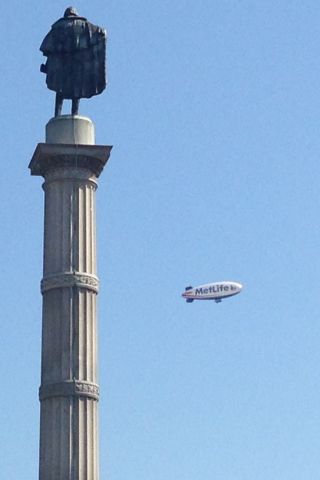 — — - MetLife Blimp over Charleston, SC with John C.Calhoun statute at Marion Square and Old Citadel for Citadel Class of 2017 Recognition and Oath ceremony.