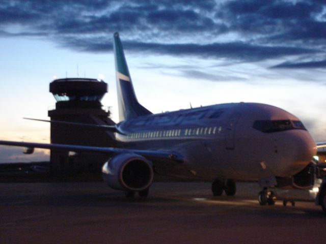 — — - Dusk at the Fort McMurray Airport with WestJet ready to depart for Edmonton, Alberta, Canada