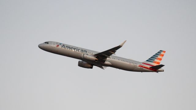 Airbus A321 (N140AN) - An evening departure from DFW as seen from Founder's Plaza. Not a lot of light to work with! Tried a slower shutter on this one.