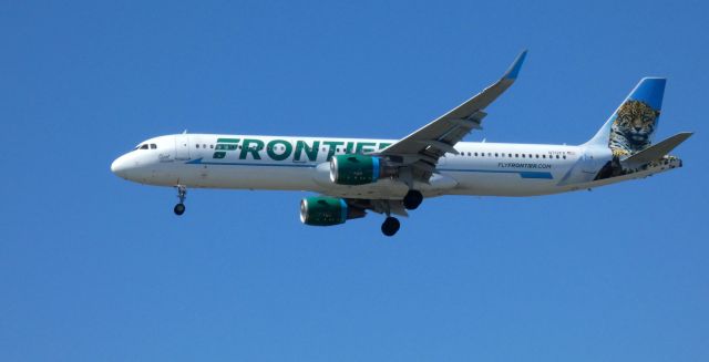 Airbus A321 (N712FR) - On final is this 2016 Frontier Airlines Airbus A321-211 with "Spot" the Jaguar looking on in the Spring of 2021.