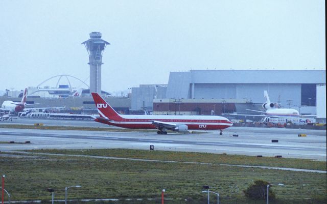 BOEING 767-300 (D-AMUR) - KLAX - Another crummy scan for the reg...but the saving grace for this was since we could not see the reg, we jumped in the truck and drove to Worldways Blvd to catch this on taxi to the terminal,,the front flap was "UR" so we had that and returned to the Hooker Hill area for more filming, this was the only German LTU 767-300 I ever saw, I got video of it landing 24R and roll out...photos crossing 24L - glad they slow rolled back,,,I was driving fast!!