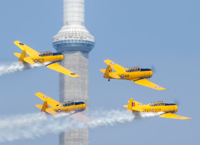 North American T-6 Texan (C-FMKA) - The Canadian Harvard Aerobatic Team fly past the CN Tower on their way back to Billy Bishop Island Airport in Toronto