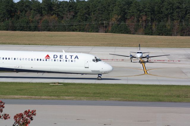 Beechcraft King Air 90 (N2NC) - N2NC waits as N964DN taxis past