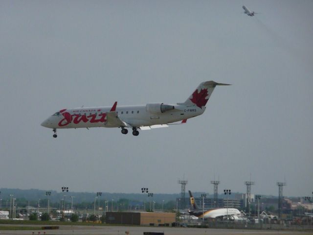 Canadair Challenger (C-FWRS) - Jazz C-FWRS landing on 12R at KMSP with NWA DC-9 taking off in the background.  May 25, 2009.