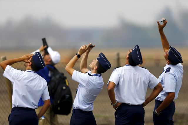 — — - CREWS & FANSbr /Members of Chiles Air Force take a break ahead of the International Air and Space Fair (FIDAE) at Santiago international airport, March 28, 2016. (Photo by Ivan Alvarado/Reuters)