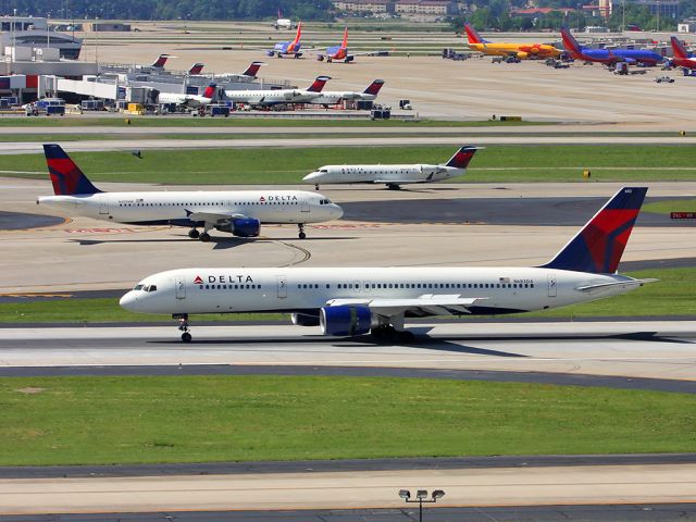 Boeing 757-200 (N683DA) - Delta 757 slowing down as some company traffic passes in the background.