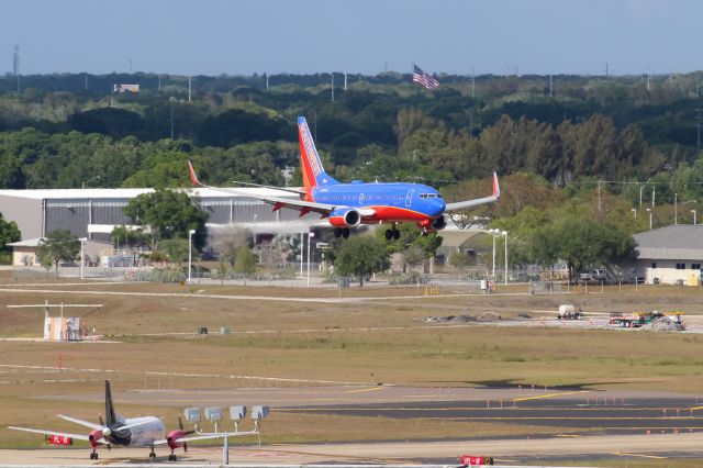 Boeing 737-700 (N7730A) - A Southwest 737-700 on short final for 19L, as a Silver Airways Saab 340 holds short.