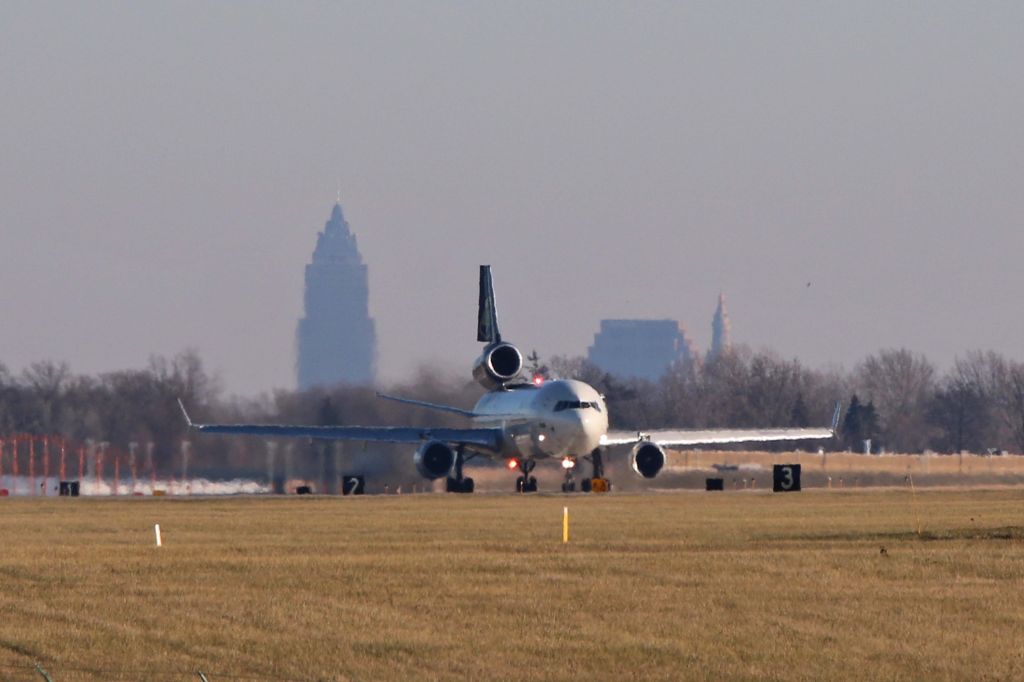 Boeing MD-11 (N275UP) - UPS9651 departing RWY 24R for Louisville Intl (KSDF) after a delay on Friday 8 Dec 2017. A few iconic landmarks can be seen in downtown Cleveland, about 10 miles northeast of Hopkins. The newest of the three is the Key Tower (left), followed by the Huntington Building (center), and finally, the historic Terminal Tower (right).
