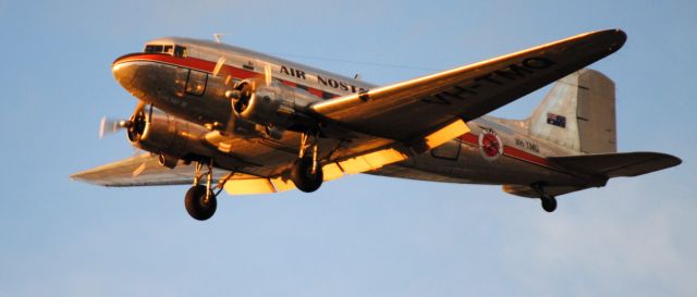 Douglas DC-3 (VH-TMQ) - on approach to Essendon airport at sunset, May 2018