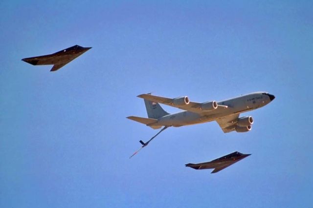 Boeing C-135B Stratolifter (61-0320) - A pair of F-117 Full Scale Development Nighthawks fly formation off the wingtips of KC-135R Stratotanker 61-0320 of the 412th Test Wing at the Edwards Air Force Base open house on October 3, 1998.