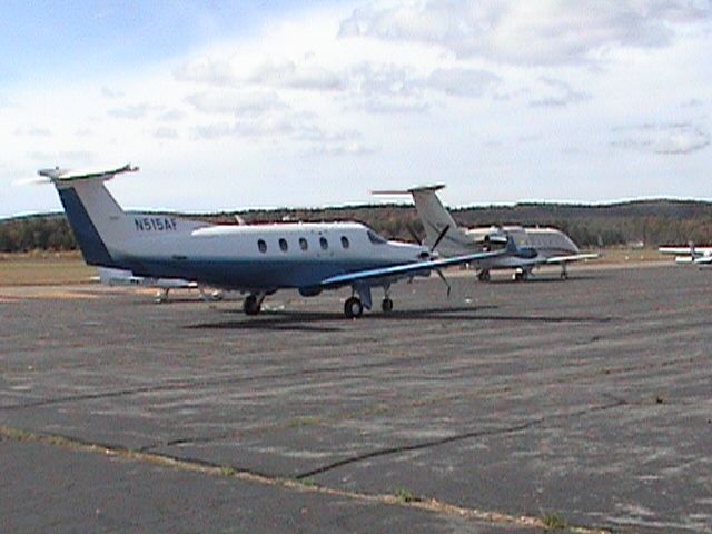 Pilatus PC-12 (N515AF) - Sitting on the ramp with a Challenger 604 in the foreground :)br /Rare sight in Orange!