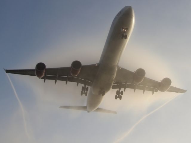 Airbus A340-600 (G-VRED) - Condensation cloud envelopes this Virgin Atlantic A340-600 as it approaches LHR early in the morning.