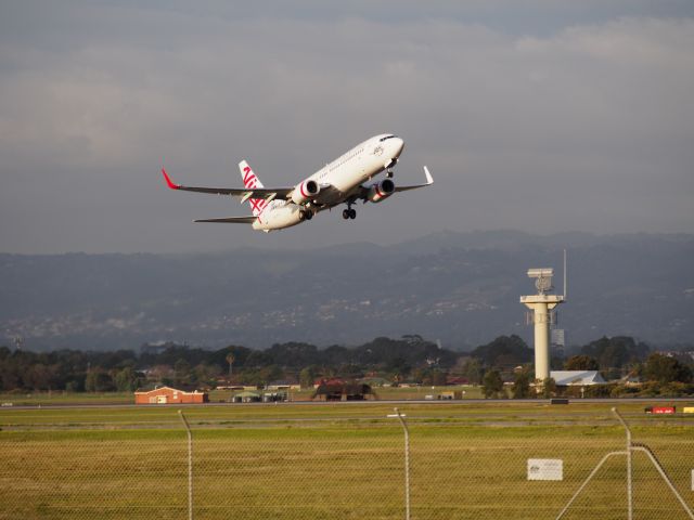 Boeing 737-700 (VH-YIY) - Lifting off from runway 23, Adelaide International Airport, with the Adelaide Hills in the background. Photo taken from the Tapleys Hill Road viewing area.