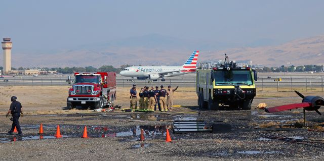 Airbus A319 (N746UW) - As an emergency crash response training exercise is being concluded with a critique session, an American A319 is unaware it is photobombing this pic as it taxies back to the KRNO terminal after landing on 16R.