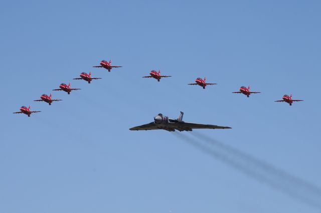 — — - The RAF Red Arrows lead a Vulcan during the latters last season on the airshow circuit.  RIAT 2015, Fairford, UK.