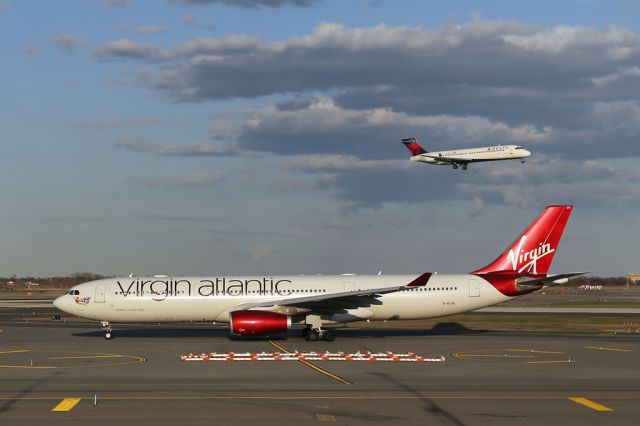 Airbus A330-300 (G-VLUV) - VIR4 going to 22R on the return to LHR as DAL1355, N937AT, arrives in the background.