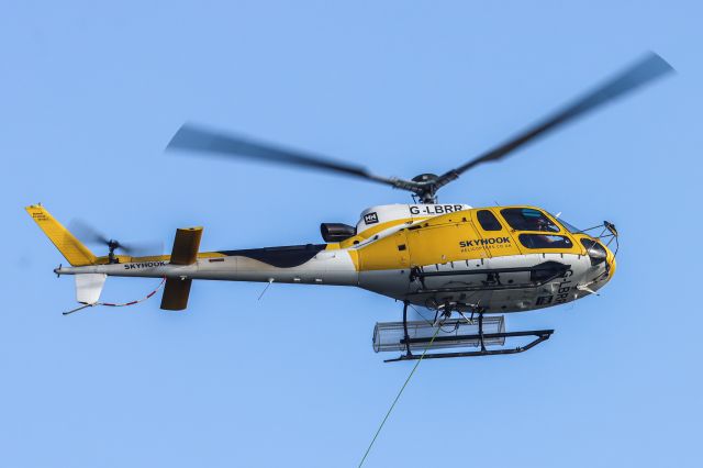 Eurocopter AS-350 AStar (G-LBRR) - Returning to pick up another load after dropping a bag of material.  Lochboisdale, Hebrides, Scotland