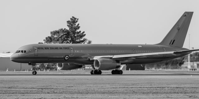 Boeing 757-200 (NZ7572) - One of our 2 gorgeous Royal New Zealand Air Force B752s about to line up on Runway 02 for a departure somewhere up in the North Island.br /On 20 July, the daily Emirates A380 had just landed from Sydney, and SOFIA, our part time NASA resident, Boeing B74S had just taken off, bound for Hawaii, and this sexy girl appeared on the taxiway. Here she is lining up on Runway 02.br /Shes painted a glossy light military gray, and with an awful mixed colour background and dull bluish sky, just had to be made into a contrasty black and white.