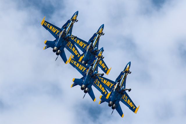 McDonnell Douglas FA-18 Hornet — - This photo is of a tailhook and landing gear down, group roll of the Blue Angels. Not only are the aircraft in an amazingly tight formation, but I thought the colors were exceptional, thus making a great photo. This photo was from the Wings over North Georgia airshow at the Rome airport. I shot this with my Canon 300mm lens with a 1.4x multiplier, thereby making the focal length 420mm. The shutter was at 1/8000, F4, ISO 400. Please check out my other aviation photography. Votes and positive comments are always appreciated. Questions about this photo can be sent to Info@FlewShots.com