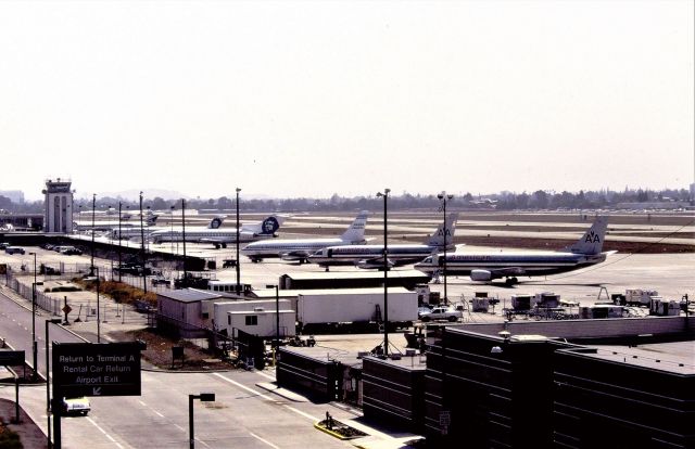 Boeing 737-200 — - KSJC - early 1990s view at San Jose on a mid day to about 2pm ugly winter photo. This is the view when the new Terminal A opened early 1990s( far right and out of view) and the adjoining parking structure was 5 stories high. This view here, from the south end of the garage and the old Terminal C and Tower visible. My son and I were the 1st paying jet photogs up here...we even sneaked up from the 4th floor as the stairwell was open one day! But I didn't want to jinx anything so we just looked around and left until opening day!. Later SJC decided to build a US Customs building and put if about where the AA 737-300 is, and towards the right in the view. Then The new Tower was built, the one shown here was disassembled, and later new Terminal C was built mid 2005-2006 forever ruining this view. I spent many years up here videotaping and photos. It was a great vantage point. Early AM summers was best and 630am Freighter arrivals were fun to watch from here.