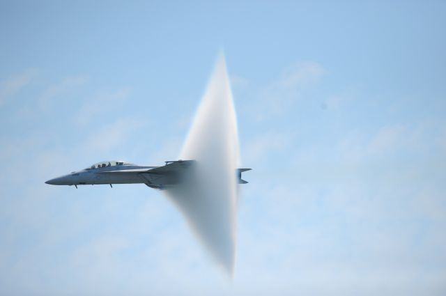 — — - A ring of water vapor is created as pilots Lt. Justin Halligan (L) and Lt. Michael Witt (R) fly their F/A-18F Super Hornet airplane within 200mph of breaking the sound barrier while performing at New York Air Show at Jones Beach in Wantagh, New York, May 23, 2009. The phenomenon is created when a plane, traveling at low altitudes over water, approaches the speed of sound and the pressure created by the forward sound waves squeezes moisture in the air to form a ball of cloud over the front of the aircraft. (Photo by Christopher Pasatieri/Reuters)