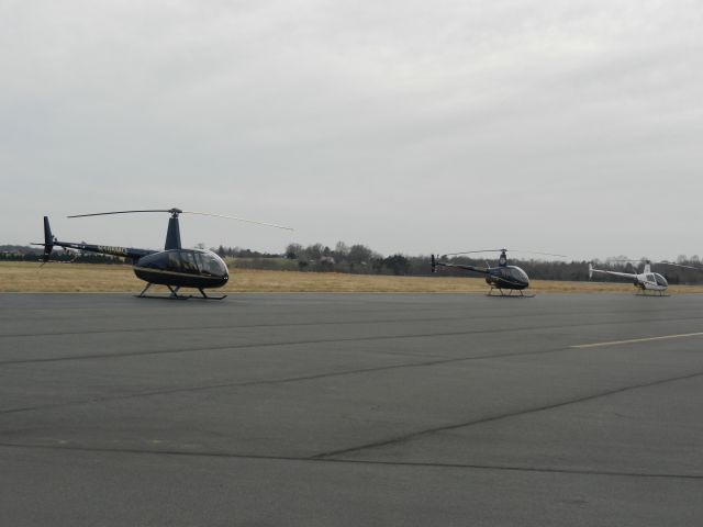 Robinson R-44 (N180MQ) - Training Helicopters Parked On The Helicopter Ramp At Manassas Airport, The Closest One Is N180MQ, A Robinson R-44, The Next One Is N2590W, A Robinson R-22, The Last Aircraft, N888GC, Is Also An R-22