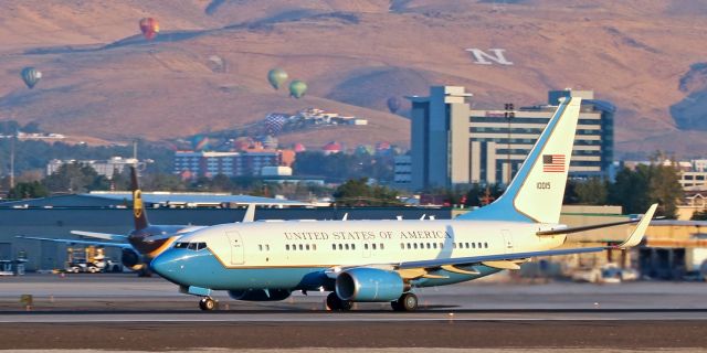 Boeing 737-700 (01-0015) - With the first of over 90 hot air balloons rising into the moment-of-sunrise early morning sky in the background, this Boeing C-40B (01-0015) accelerates along 16R as it departs Reno after a weekend stay.