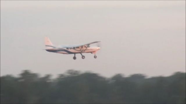 Cessna Caravan (N208TS) - "Skydive Myrtle Beach" Cessna 208 Caravan "Jump 1" climbing out on takeoff from Grand Strand Airport (KCRE) in North Myrtle Beach, SC with a full Sunrise Jump Load at 7 AM. Date of image is 8/22/2015. Morning Sun is reflecting off Propeller Hub.