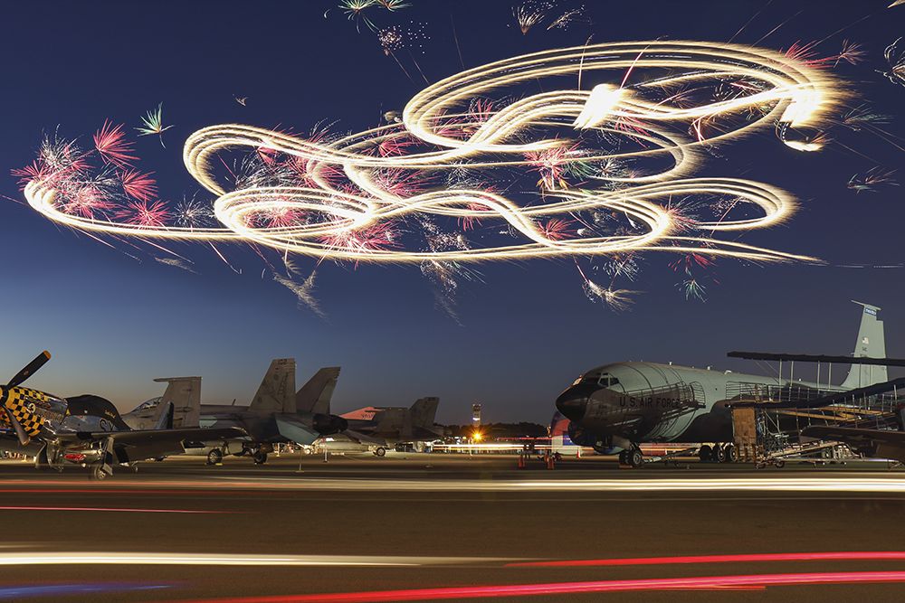 — — - Aerial fireworks display where the fireworks are attached to an aircraft. Really cool long exposure photo from Sun N Fun in Lakeland Florida. Questions about this photo can be sent to Info@FlewShots.com