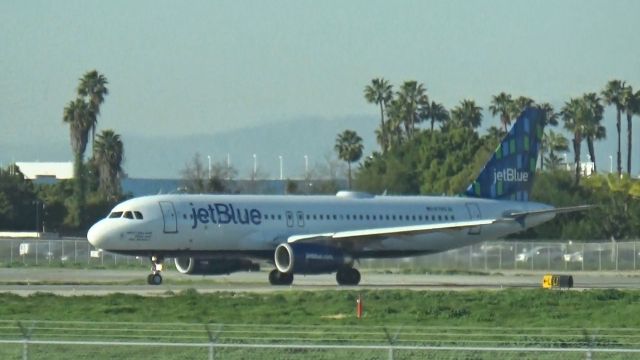 Airbus A320 (N789JB) - "What's Blue and White and Flies all over?" is holding short of Runway 30 which is headed to Salt Lake City, while N509JB "True Blue" lands.