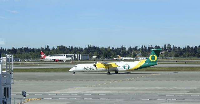 de Havilland Dash 8-400 (N407QX) - 043014 Ducks taxiing out, VA A320 N853VA on take-off roll.