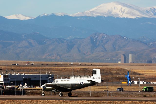 Beechcraft Queen Air (65) (N5078U) - On taxiway M.  Our vast brown prairie is seen to good affect. In the background you can see DIAs giant blue horse, "BLUCIFER", downtown Denver, Mount Evans, and cars on Pena Boulevard.