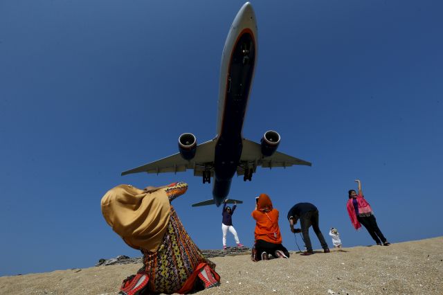 — — - Tourist take pictures at Mai Khao Beach, as a plane approaches the Phuket International Airport in Phuket, Thailand March 17, 2016. With its palm-fringed beaches, Buddhist culture and racy nightlife, Thailand has been the poster child for Asian tourism for decades, attracting a range of visitors from backpackers and adventure-seekers, to families and culture vultures. But dark clouds could be forming even as a record of 32 million tourists are expected this year. (Photo by Athit Perawongmetha/Reuters)
