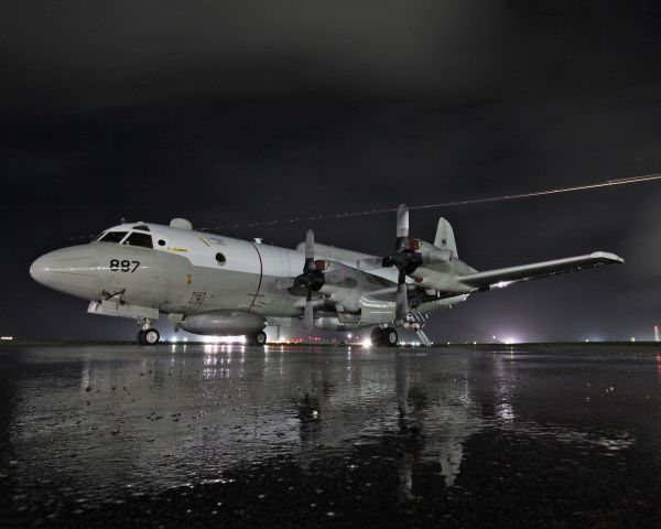 Lockheed P-3 Orion (15-9887) - EP-3E from VQ-1 World Watchers.  A C-130 is departing in the background.  Night shot was at a base in the Pacific.  This photo is a lot sharper on Flickr, however, Im not sure why it all looks soft on here.  30 second exposure, Canon 10-22mm lens, Canon 50D body.  Photo cleared through proper channels, official photo credit is to LT Scott Shea, USN (me).