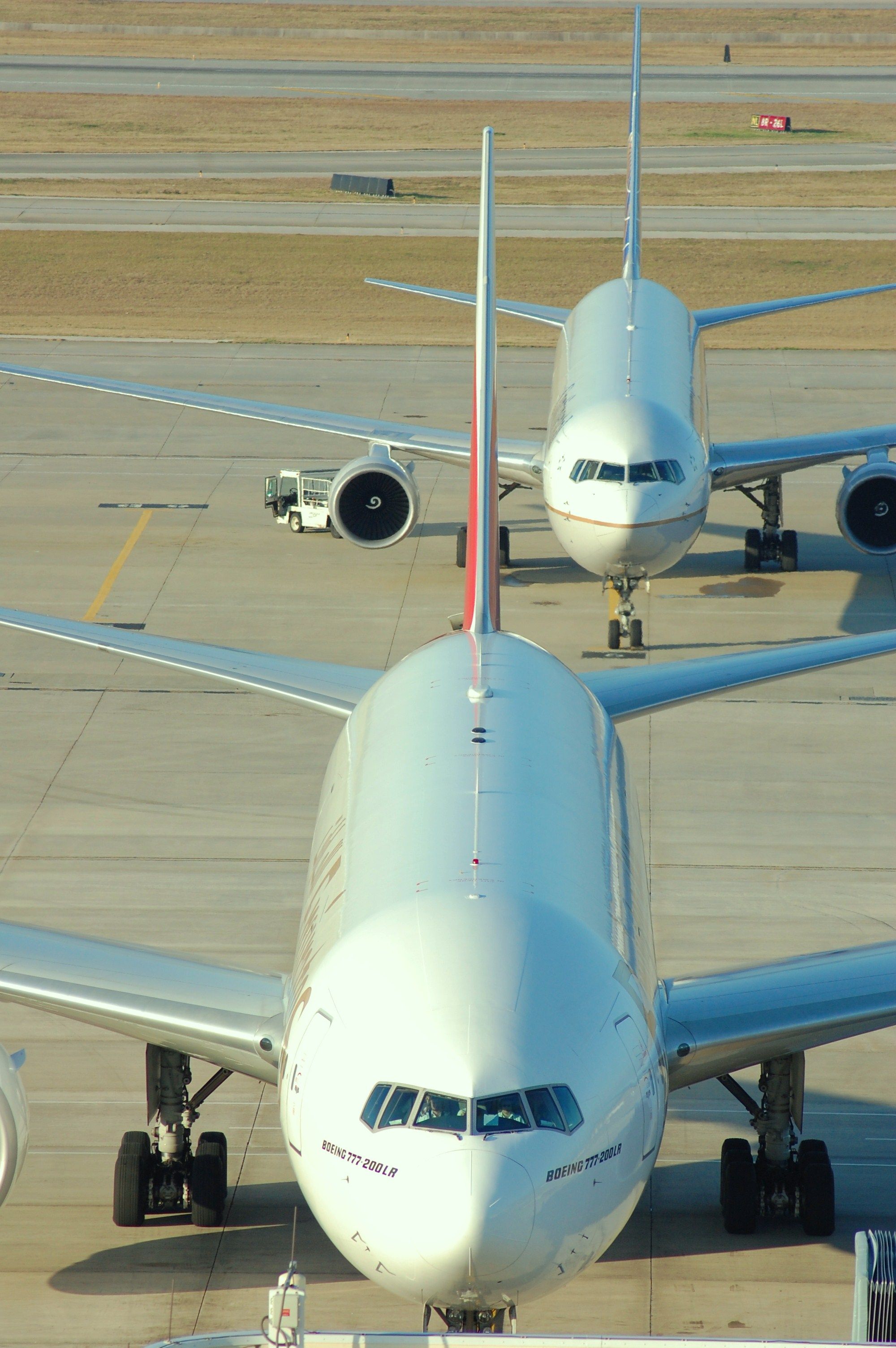 — — - Emirates 211 and a parked Boeing 767.