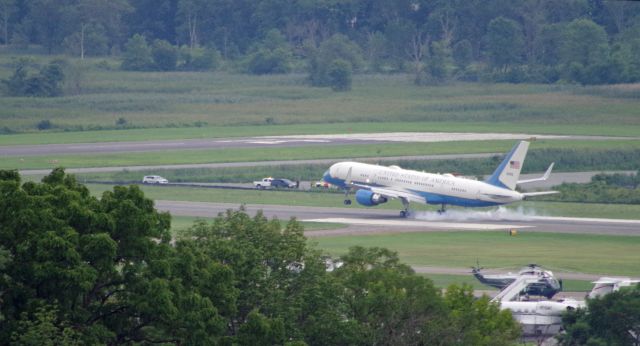 Boeing 757-200 (09-0015) - MORRISTOWN, NEW JERSEY, USA-AUGUST 14, 2020: On a cloudy and overcast day, Air Force One is seen just as it touches down on Runway 5 at Morristown Municipal Airport. President Trump is spending the weekend at his golf club in Bedminster, New Jersey. When flying into or out of Morristown Airport, the Air Force uses the Boeing 757-200 as Air Force One, instead of the larger 747, because of shorter runways at Morristown. Also pictured, in the foreground, is the helicopter that will become Marine One in a few minutes. Photo taken from approximately one mile away.