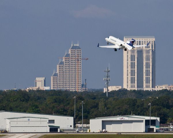 Learjet 45 (N821LC) - A departing Learjer 45 against downtown Orlando on a Sunday morning.