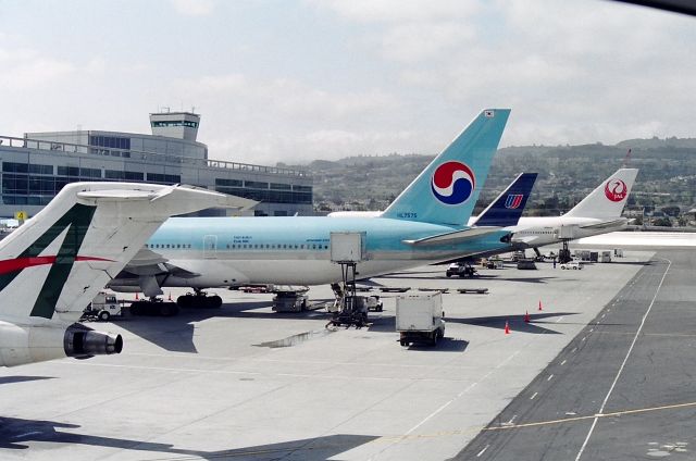 Boeing 777-200 (HL7575) - KSFO - early 2000 at SFO roaming the new terminal. View looking west. The 727 is Allegro XA-TLZ