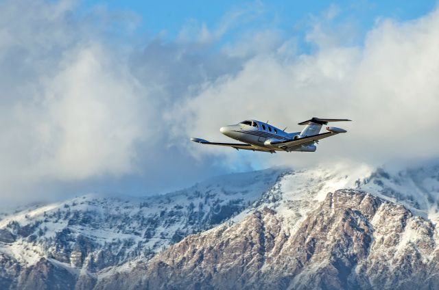 Eclipse 500 (N570RG) - Caught this light jet taking off from runway 21 at sunset against snow capped mountains and clouds. Oh ya!